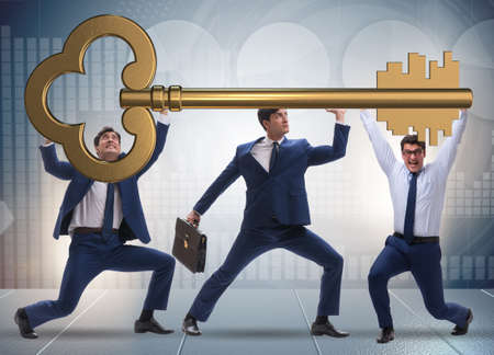 Businessmen holding giant key in business conceptの写真素材