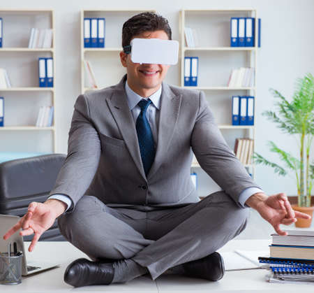 The businessman in virtual reality vr glasses meditating at desk