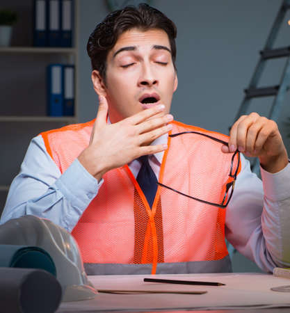 Construction architect working on drawings late at nightの写真素材