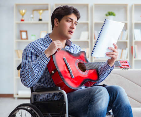 Disabled man playing guitar at home