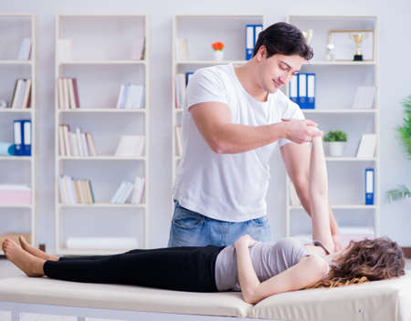 Young doctor chiropractor massaging female patient womanの写真素材