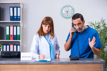 Two doctors working at the reception in the hospital