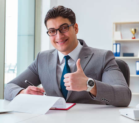 Businessman signing business documents in office
