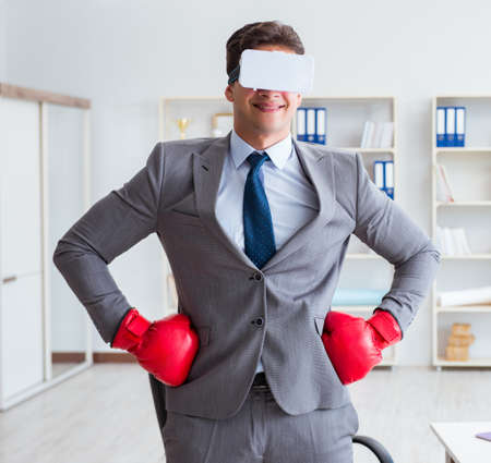 Man boxing in the office with virtual reality gogglesの写真素材
