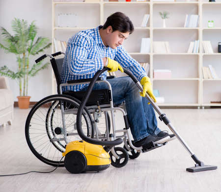 Disabled man cleaning home with vacuum cleanerの写真素材
