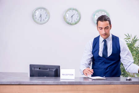 Young man receptionist at the hotel counterの写真素材