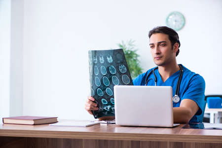 Young male doctor looking at x-ray images