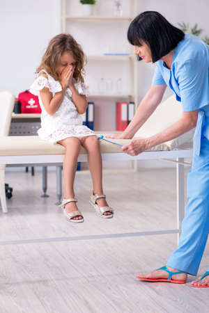 Little girl visiting old female doctorの写真素材