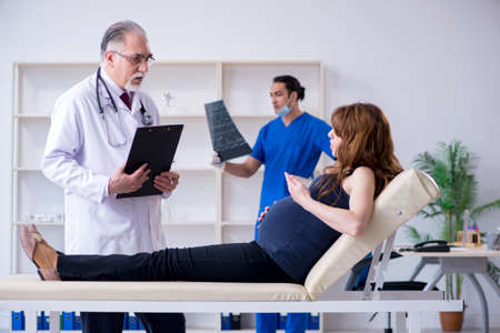 Two doctors examining young womanの写真素材