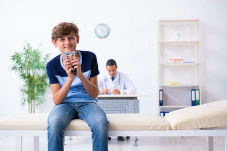 Young male doctor examining boy in the clinicの写真素材