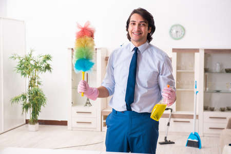 Young businessman cleaning the houseの写真素材