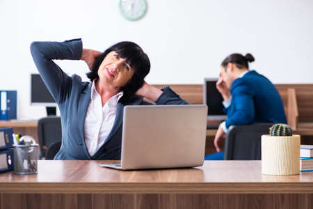 Two employees doing sport exercises in the officeの写真素材