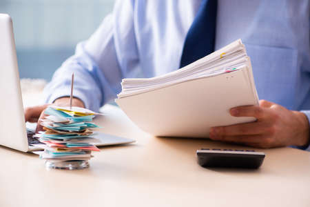 Young male employee in budget planning conceptの写真素材