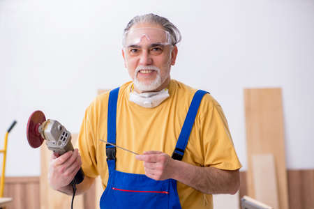 Old male carpenter working in workshopの写真素材