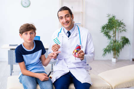 Young male doctor examining boy in the clinicの写真素材