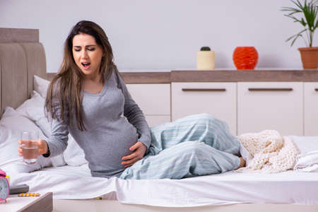 Young pregnant woman in the bedroomの写真素材