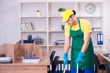 Young male contractor cleaning the office