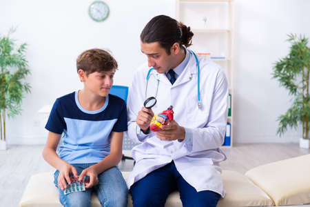 Young male doctor examining boy in the clinicの写真素材