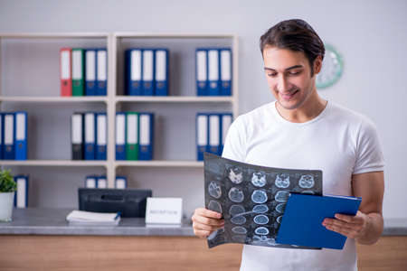 Young man at hospital reception desk