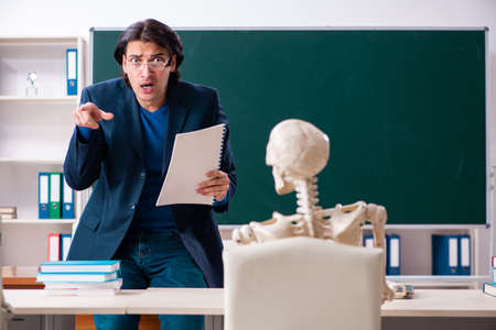 Male teacher and skeleton student in the classroomの写真素材
