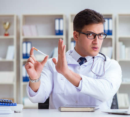 Male doctor in anti-smoking concept with cigarette packの写真素材