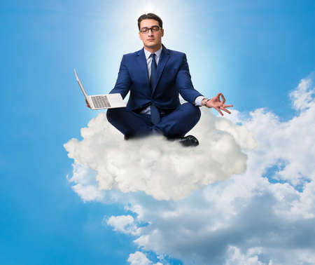 Businessman working on laptop in the skyの写真素材