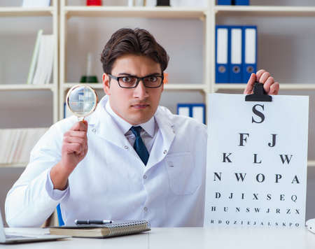 Doctor optician with letter chart conducting an eye test check