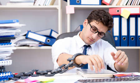 The employee attached and chained to his desk with chainの写真素材