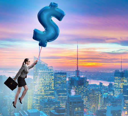 The businesswoman flying on dollar sign inflatable balloonの写真素材