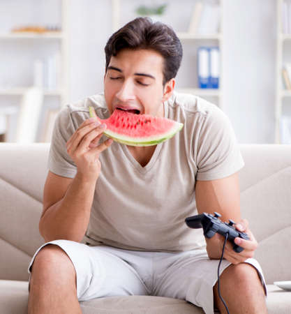 Man eating watermelon at homeの写真素材