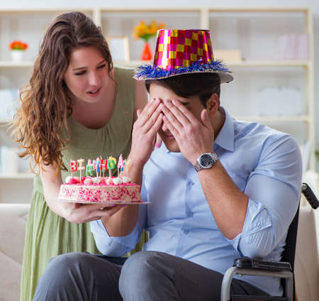 Young family celebrating birthday with disabled personの写真素材