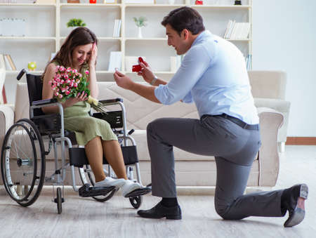 The man making marriage proposal to disabled woman on wheelchairの写真素材