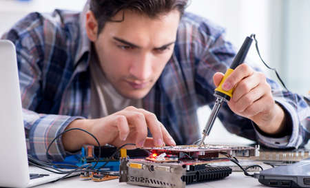 The professional repairman repairing computer in workshop