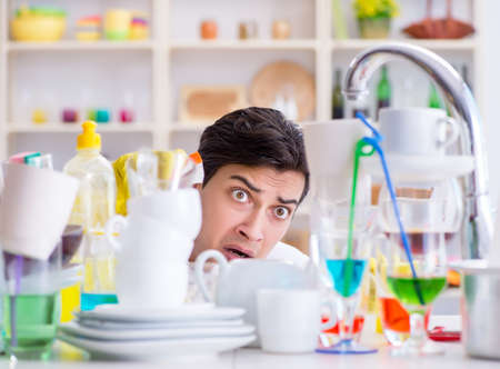 Man frustrated at having to wash dishesの写真素材