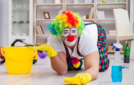 Funny clown doing cleaning at homeの写真素材