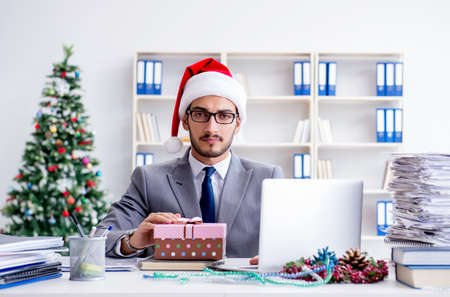 Young businessman celebrating christmas in the officeの写真素材