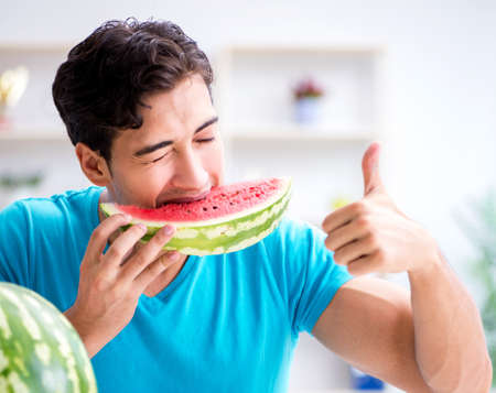 Man eating watermelon at homeの写真素材