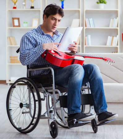 Disabled man playing guitar at homeの写真素材
