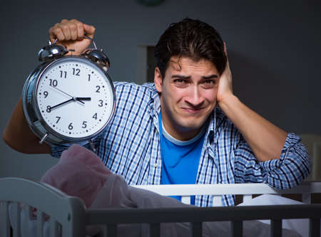 The young father under stress due to baby crying at nightの写真素材