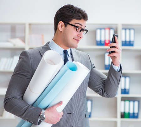 Businessman engineer draftsman with blueprints drawingsの写真素材