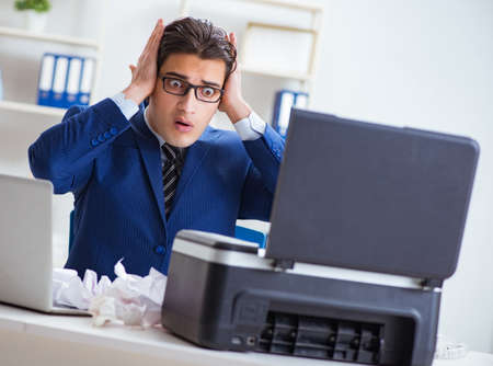 Businessman angry at copying machine jamming papers