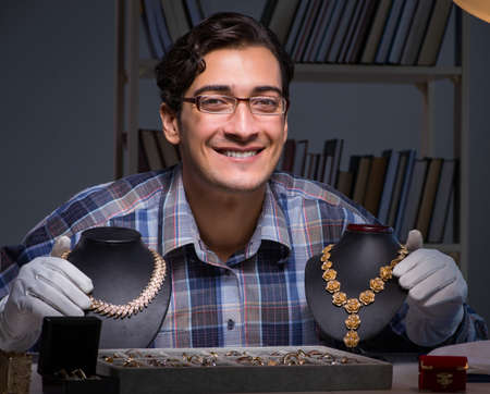 The young male jewellery working at night in his workshop