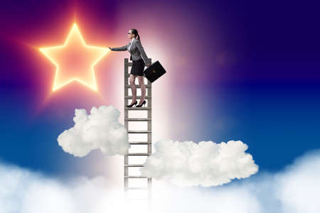 Businesswoman reaching out for stars in success conceptの写真素材