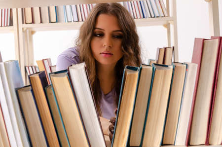 Young female student preparing for exams at libraryの写真素材