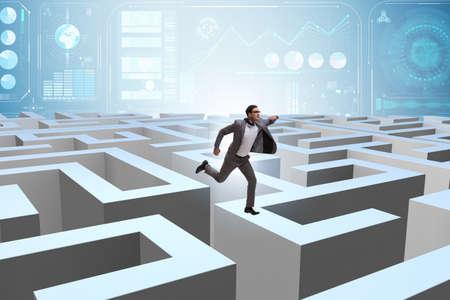 Businessman trying to escape from mazeの写真素材