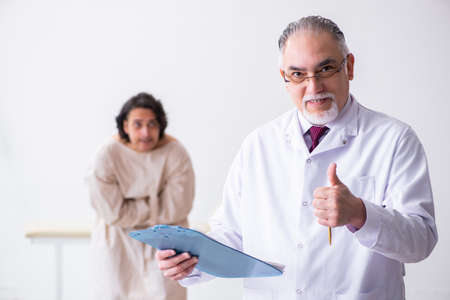 Aged male doctor psychiatrist examining young patientの写真素材