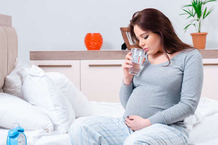 Young pregnant woman in the bedroomの写真素材
