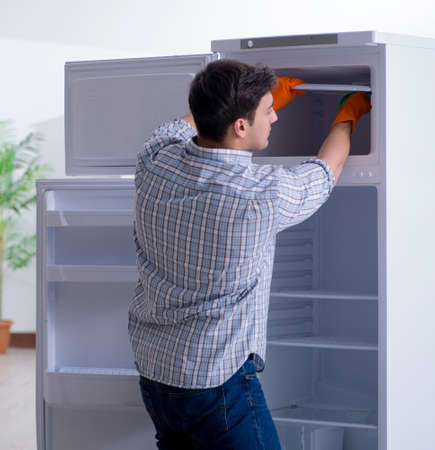 Man cleaning fridge in hygiene conceptの写真素材
