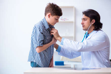 Male doctor examining boy by stethoscopeの写真素材