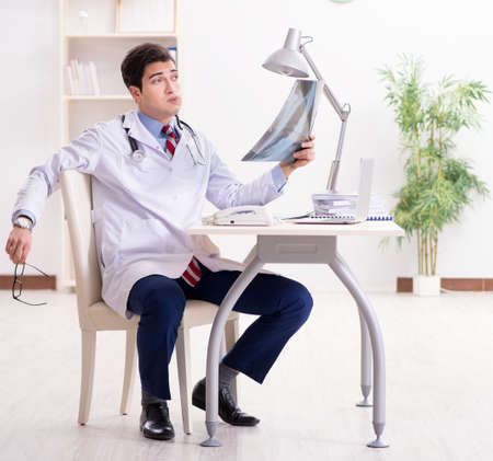 Young handsome doctor working in hospital roomの写真素材